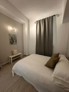 Un dormitorio con una gran cama blanca con una cortina. en L'Angolo Rosa, en Casale Monferrato