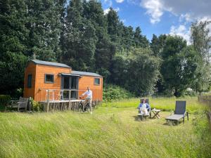 a couple of people sitting in front of a tiny house at Joly Tiny House in Overijse