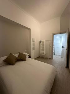 Un dormitorio con una gran cama blanca y una puerta en L'Angolo Rosa, en Casale Monferrato