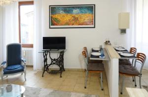 ein Wohnzimmer mit Tisch und Stühlen und einem Fernseher in der Unterkunft Casa Maribel in Luino