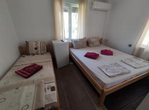 a room with two beds and a refrigerator at Mercury Guest House in Veliko Tŭrnovo