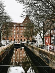 a river in a city with buildings and a building at Hotel Zur Mühle in Buxtehude