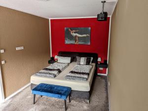 a bedroom with two beds and a red wall at Ferienwohnungen Heimkino Cochem in Cochem