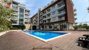 a swimming pool in front of a building at Stamopolulux директен изглед към морето in Primorsko