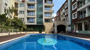 an empty swimming pool in front of a building at Stamopolulux директен изглед към морето in Primorsko
