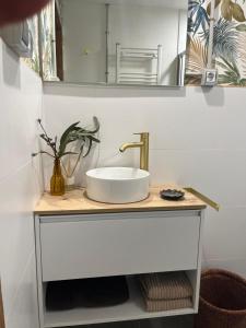 Un mostrador de baño con un lavabo y un espejo. en Mirada Do Roxo, en Oia