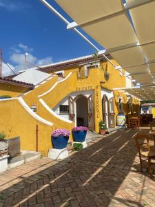 a yellow building with potted plants in front of it at Oriente Camere in San Nicola Arcella
