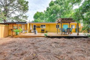 una pequeña casa amarilla con terraza y sillas en Fort Walton Beach Home about 2 Mi to Okaloosa Island!, en Fort Walton Beach
