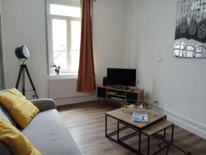 un soggiorno con un divano e un tavolo di Le Sunny-Appartement duplex spacieux a Outreau