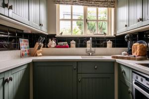 une cuisine avec des armoires vertes et un évier dans l'établissement Rose Cottage, à High Bickington