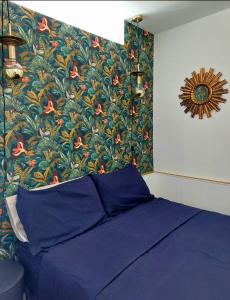 una camera con un letto blu e carta da parati floreale di Gran Park Benidorm a Benidorm