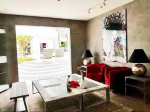 a living room with a red couch and a table at Studio Unit at La Bella Tagaytay Residences in Tagaytay