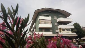 a green and white building with flowers in front of it at Casa Luciano Bellaria Centro in Bellaria-Igea Marina +54 photos