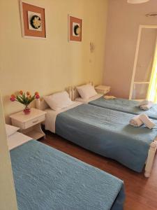 een slaapkamer met twee bedden en een tafel met bloemen bij Firefly Studios Georgios 11 in Corfu +8 foto's