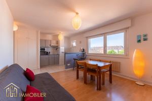 een woonkamer met een bank en een tafel bij Appartement L'Orient - Parking in Colmar