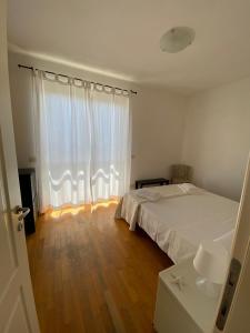 a bedroom with a bed and a large window at Voglia di mare Versilia in Querceta +4 photos