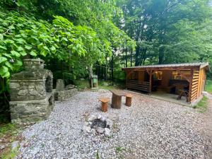 a cabin in the woods with a fire pit at Glamping Krn in Kobarid +10 photos