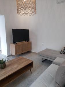 a living room with a flat screen tv on a stand at Kosmos Retreat in Kos