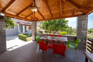 a patio with a table and chairs under a wooden ceiling at Vila Ylli Gjika in Ksamil