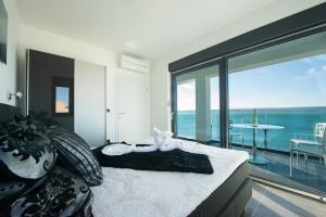 a bedroom with a bed with a view of the ocean at Design-Beachresort - with Pool - first line to the sea in Maslenica