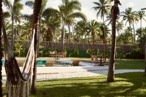 a resort with a swimming pool and palm trees at Terrasa Solar Hotel in Icaraí