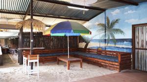 a bench with a colorful umbrella in a restaurant at LAKE-HOUSE CABIN in Witbank