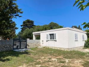 a white house with a fence and trees at Apartments Silba in Silba +3 photos