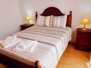 a bedroom with a large bed with two lamps at Casa Rocha Relax in Aljezur