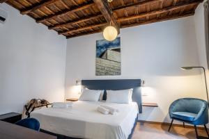 een slaapkamer met een bed en een blauwe stoel bij Fantini Rooms-Monti in Rome