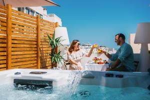a group of people sitting around a table in a hot tub at Giorgio Boutique Hotel in Sliema