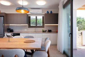 Una cocina con una mesa y sillas de madera. en Villa Shine, en Roussospítion