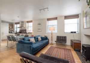 Una sala de estar con un sofá azul y una mesa. en Causewayside Apartment - The Edinburgh Address, en Edimburgo