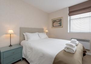 Un dormitorio con una gran cama blanca y una ventana. en Causewayside Apartment - The Edinburgh Address, en Edimburgo