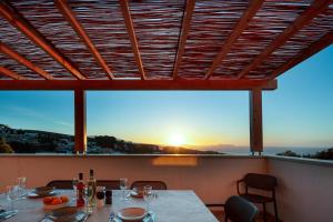 mesa de comedor con vistas a la puesta de sol en Villa Shine, en Roussospítion