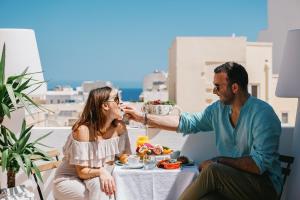 a man feeding a woman a plate of food at Giorgio Boutique Hotel in Sliema