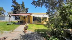 einen Garten mit einem gelben Haus und einer Terrasse in der Unterkunft Casa Rustica in El Puerto de Santa María