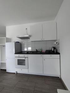 Biała kuchnia z białymi szafkami i lodówką w obiekcie Concept Köln w Kolonii +3 zdjęcia