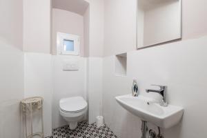 a white bathroom with a toilet and a sink at Nada apartment in Rijeka +12 photos
