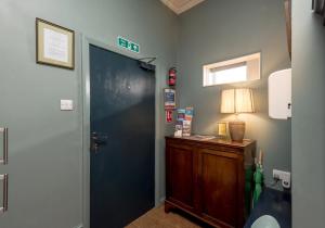 un pasillo con una puerta y una lámpara sobre una mesa en Causewayside Apartment - The Edinburgh Address, en Edimburgo 23 fotos más