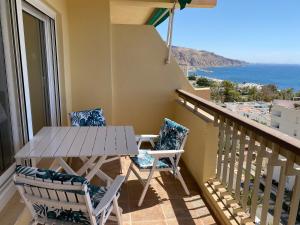 a balcony with a table and chairs and the ocean at Apartamento El Palmeral Aguadulce in Aguadulce