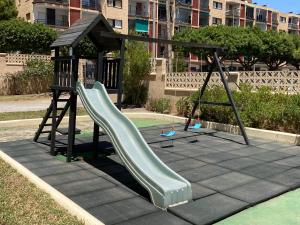 a playground with a slide and a play structure at Apartamento El Palmeral Aguadulce in Aguadulce
