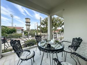 a patio with a table and chairs on a balcony at The Serenity Villa #PROPERTLY in Nea Kallikrateia