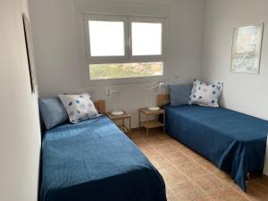 a bedroom with two beds and a window at Apartamento El Palmeral Aguadulce in Aguadulce +12 photos