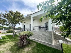 a white house with a patio and a yard at The Serenity Villa #PROPERTLY in Nea Kallikrateia