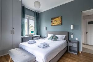 アテネにあるPark view apartment in Chalandriのベッドルーム1室(青い壁の大きな白いベッド1台付)