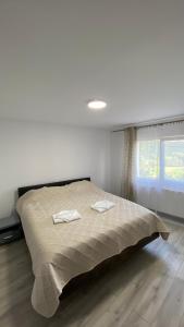 a bedroom with a bed with two towels on it at Casa NICORAD Apartamente in Pucioasa