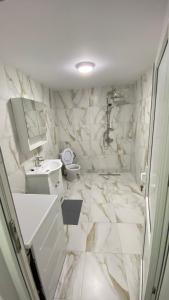 a white bathroom with a sink and a toilet at Casa NICORAD Apartamente in Pucioasa +8 photos