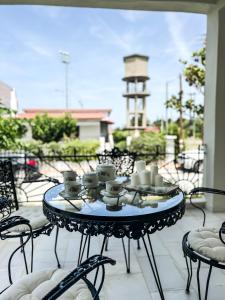 a table with cups and saucers on a patio at The Serenity Villa #PROPERTLY in Nea Kallikrateia