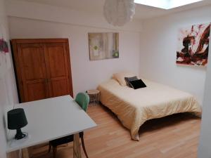 a bedroom with two beds and a desk and a table at Residences Florale à Thionville - Coliving - Studios - Appartements in Thionville