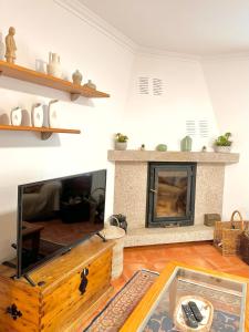 a living room with a fireplace and a table at Casa da Touça in Arcos de Valdevez +49 photos